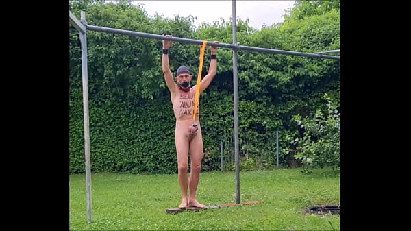 naked slave pig exposed in penis cage outdoor in spite of rain, tied up at testicles entertain the party guests