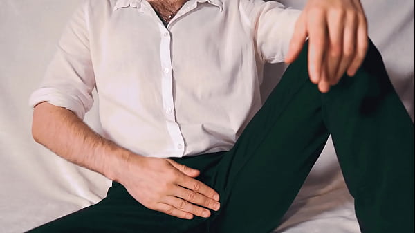 Handsome Noel Dero watches porn and caresses his dick in a condom close-up.